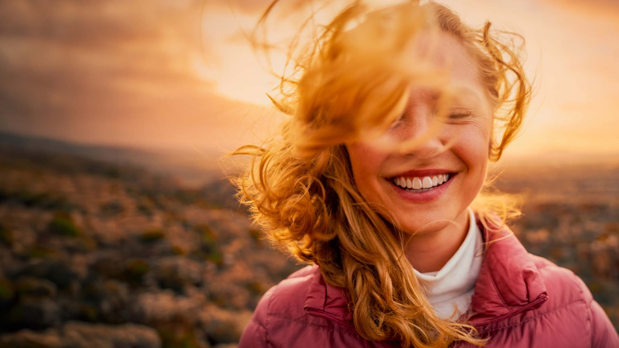 woman-outdoor-sunrise-smiling-hero-16-9-2560x1440px
