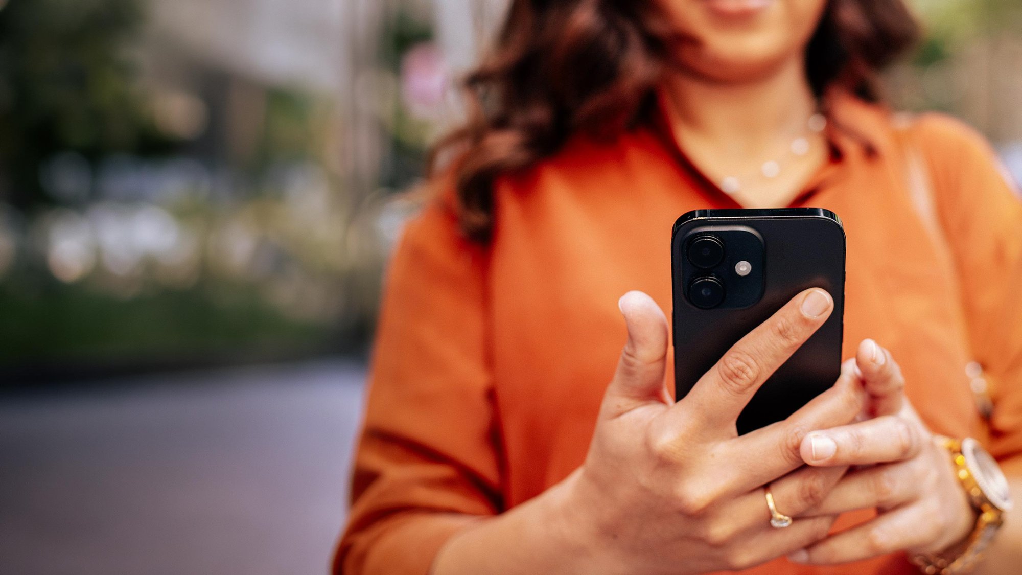woman-using-phone-outside-closeup-hero-16-9-2560x1440px