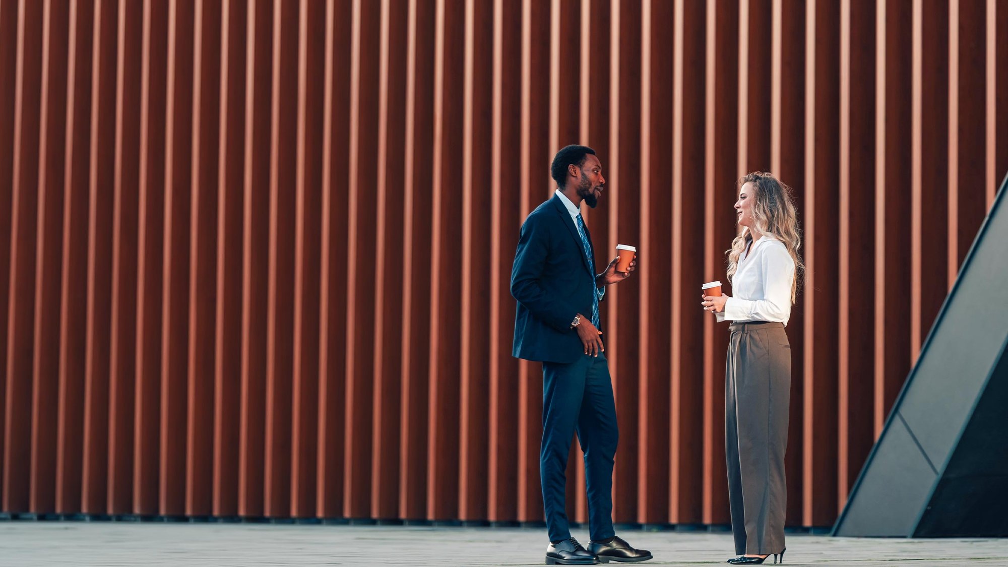 woman-man-meeting-building-coffee-hero-16-9-2560x1440px