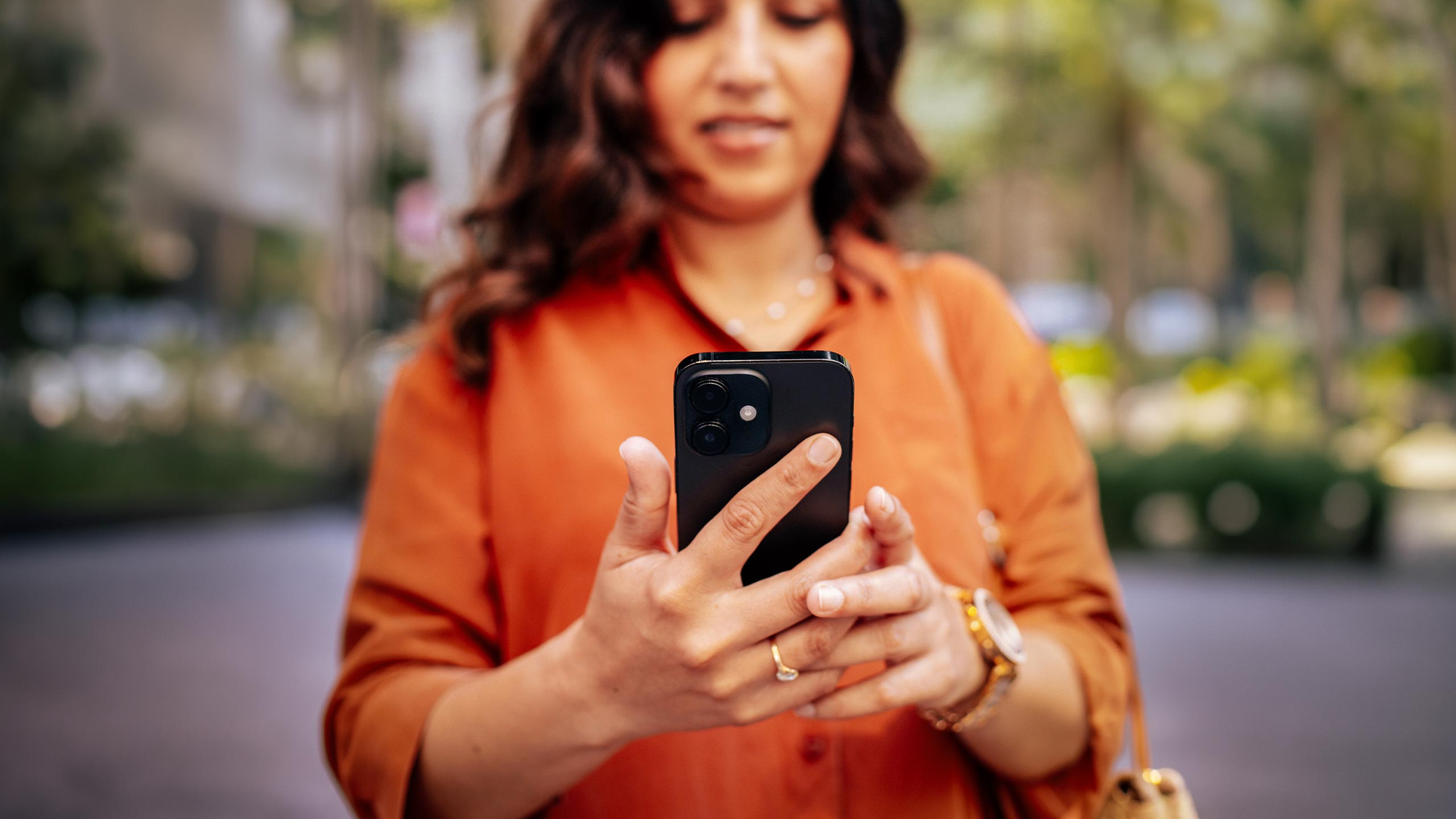 woman-using-phone-outside-closeup-large-16-9-2560x1440px